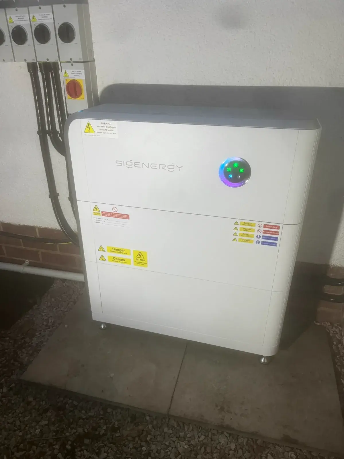 Sigenergy compact battery unit on exterior wall with LED status ring