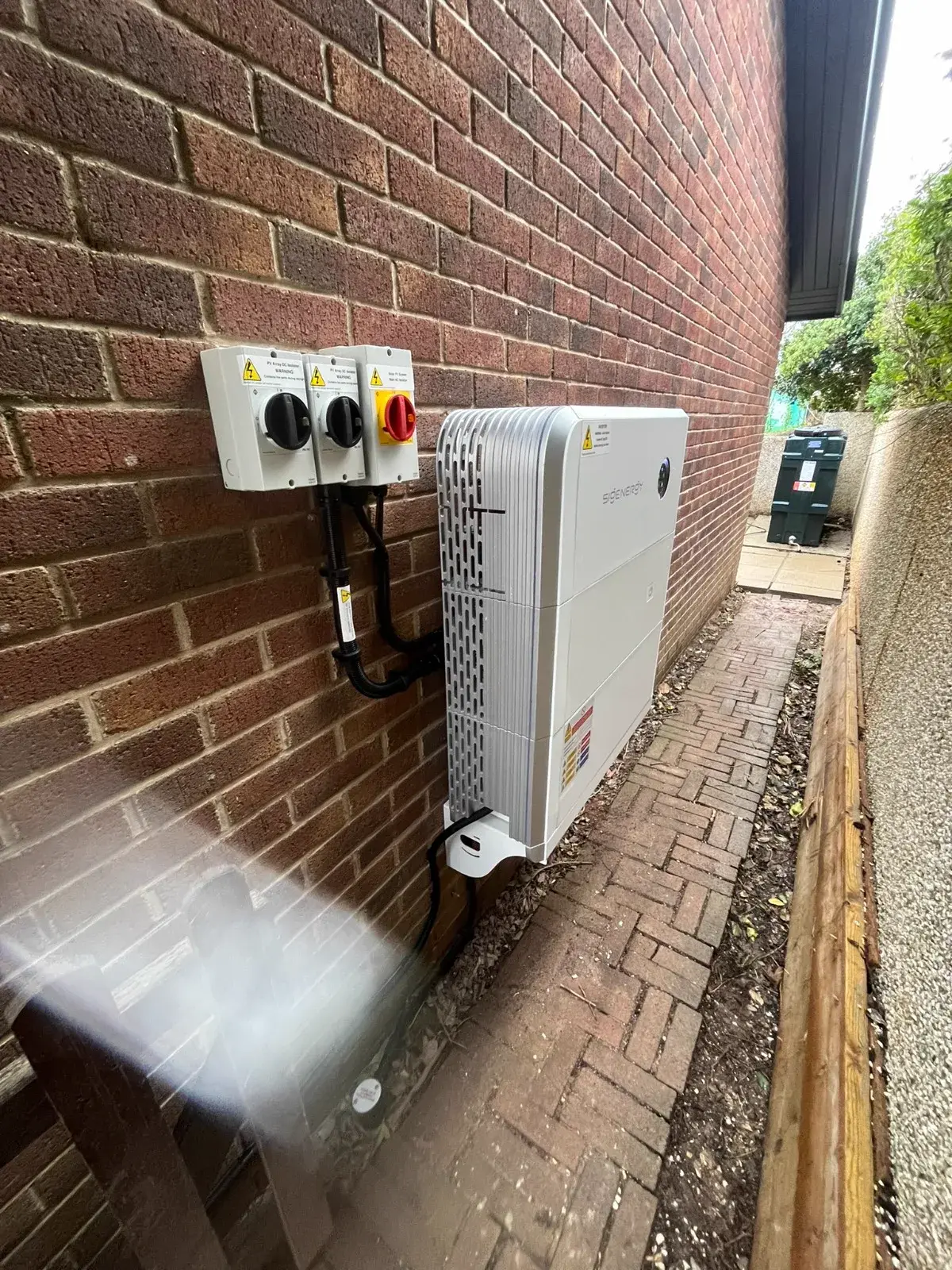 Fox ESS hybrid inverter installed on exterior brick wall
