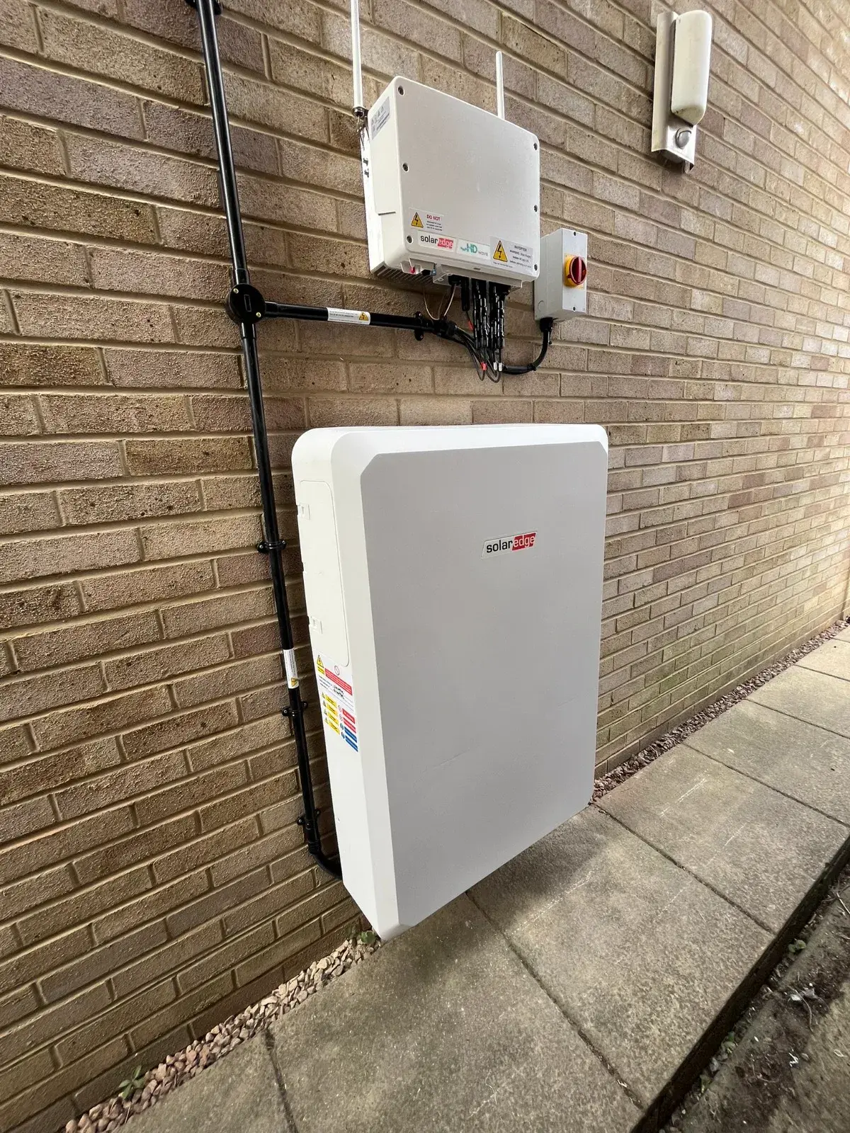 SolarEdge Home Battery installed on exterior brick wall