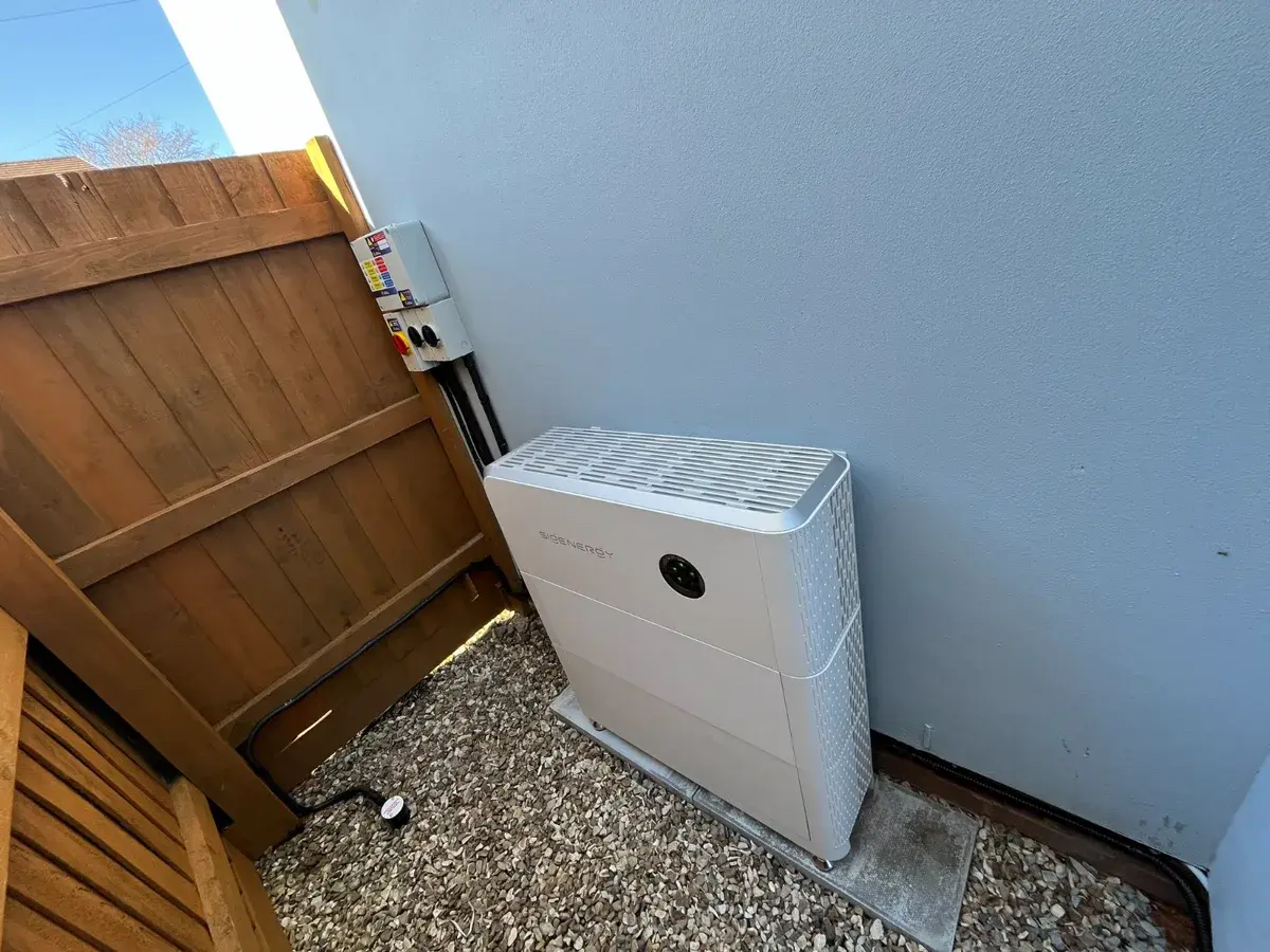 Tesla Powerwall 3 with glowing Tesla logo in stone outbuilding
