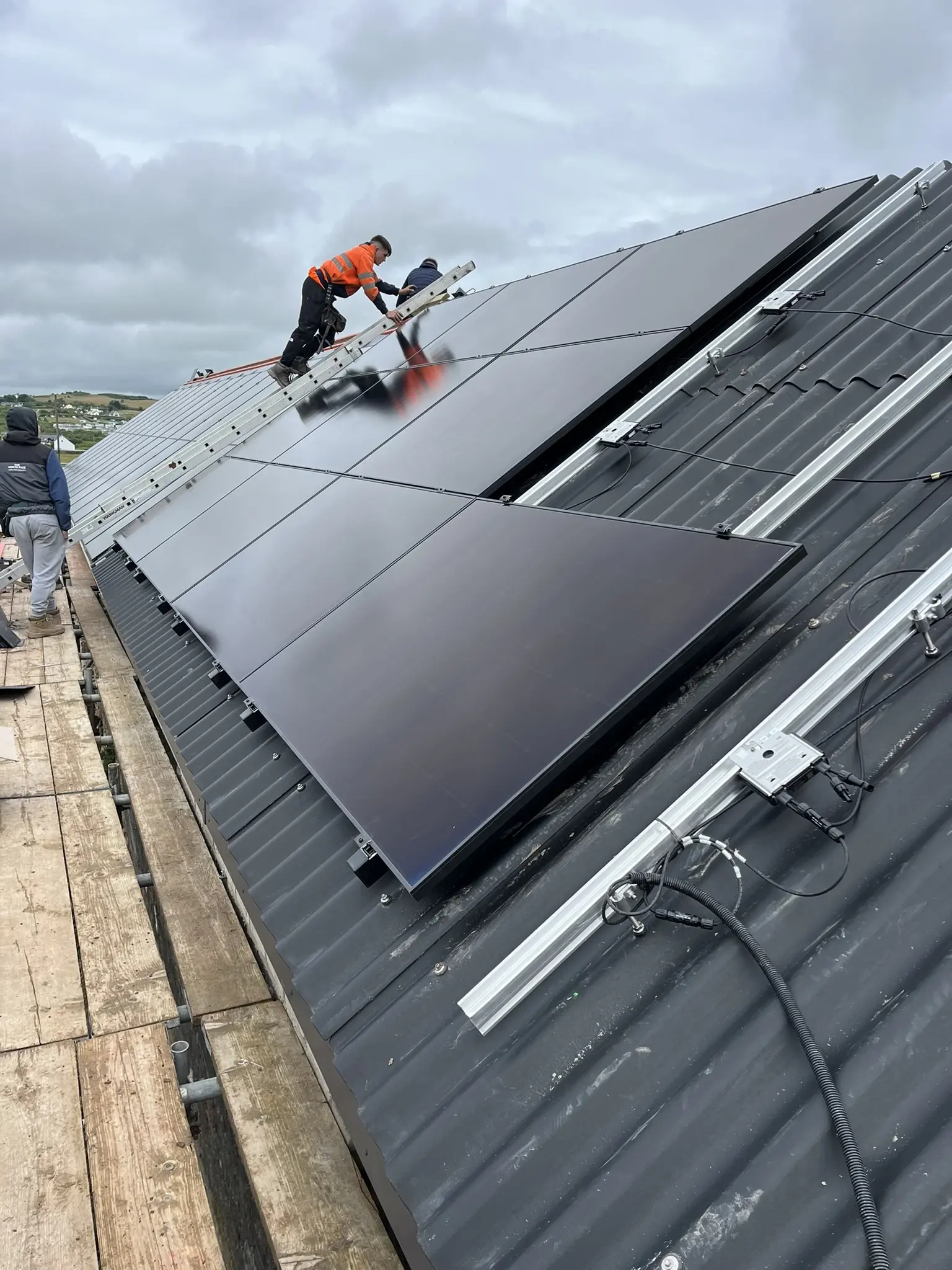 Installers placing solar panels on commercial metal roof