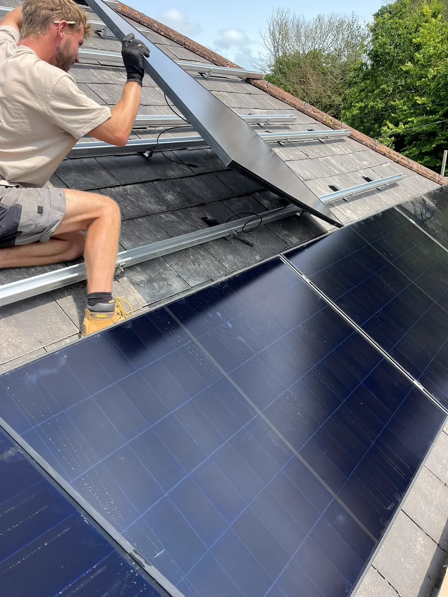Installer fitting solar panel on residential roof