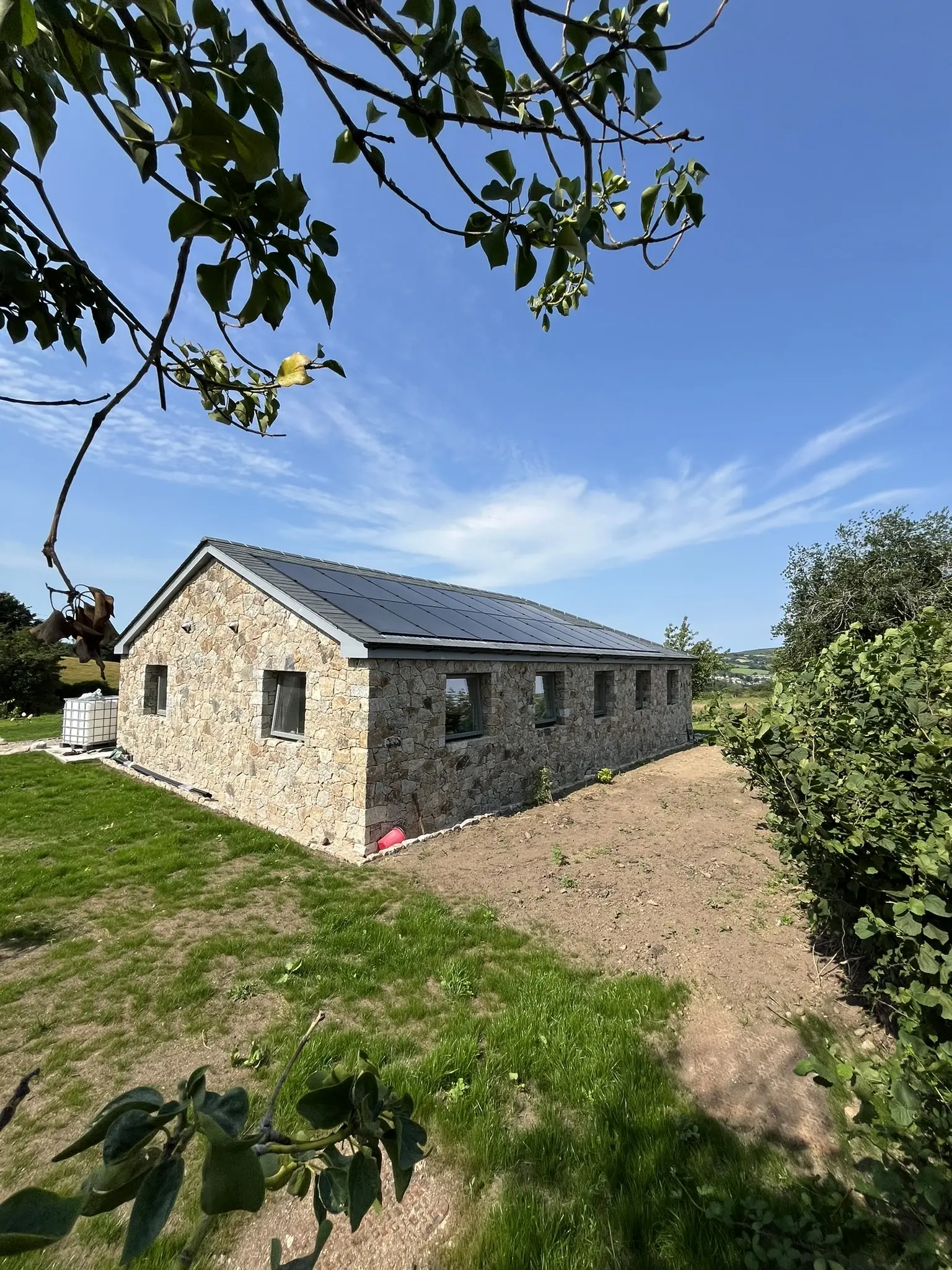Solar panels on stone cottage roof in Devon countryside