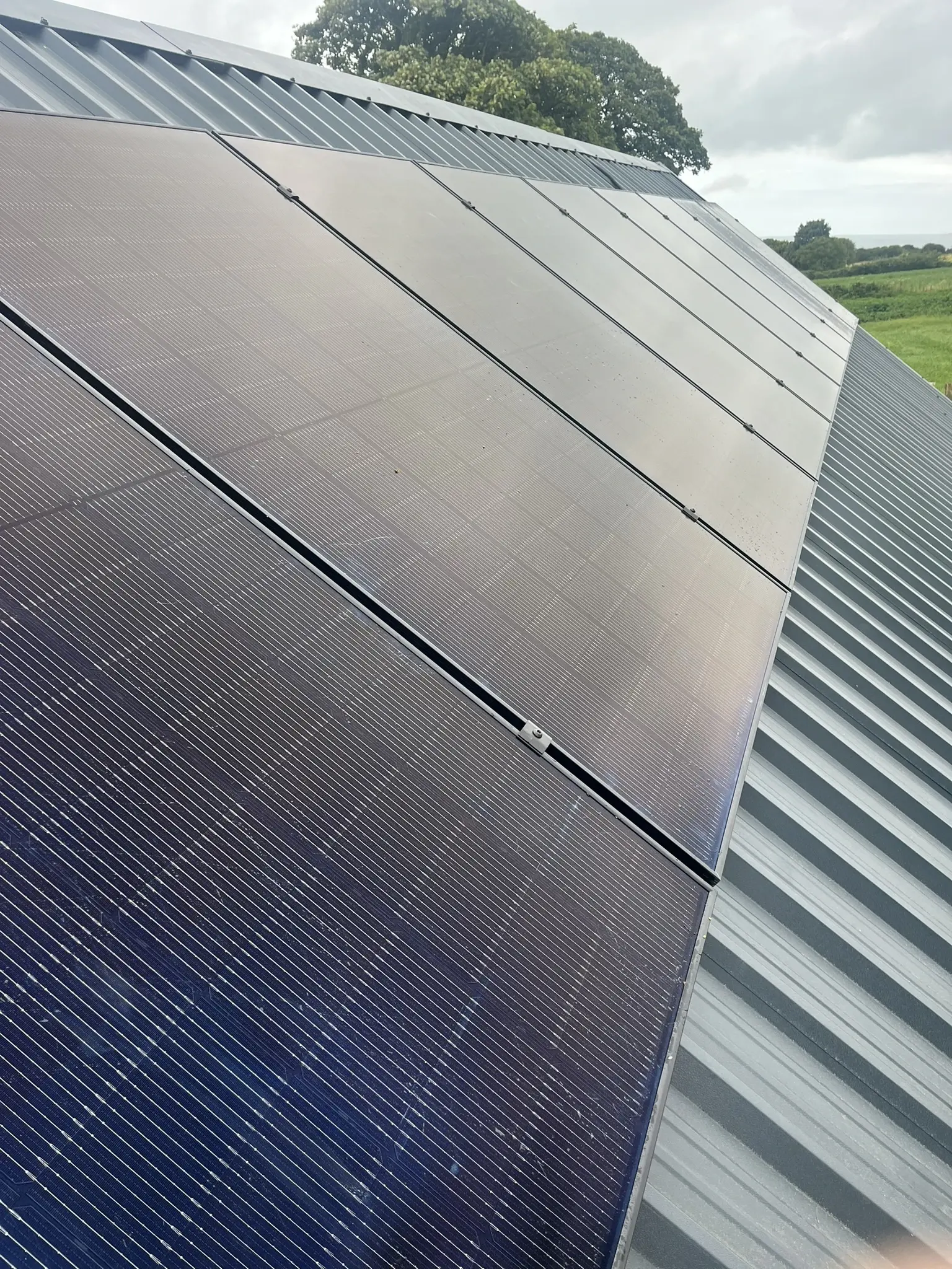 Solar panels on metal roof with countryside backdrop
